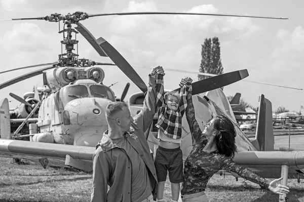 I believe I can fly. Family couple with son on vacation travel. Woman and man with boy child at helicopter. Air tour and travel. Enjoying travelling by air. Happy family vacation