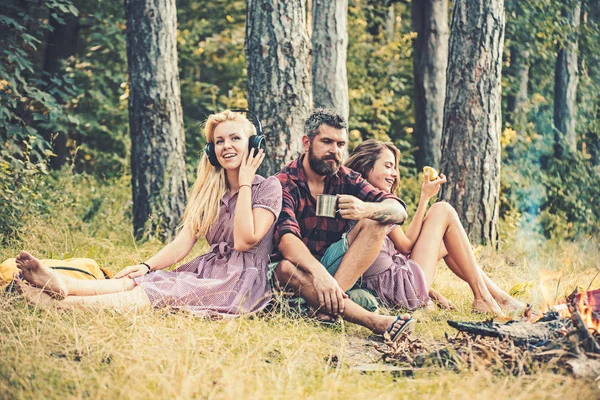 Kamp ateşi alevleri izlerken çay kahve içme sakallı düşünceli adam. Sarışın kız kardeşi yeme elma ise müzik. Çeşitli mükemmel rahatlama algısı