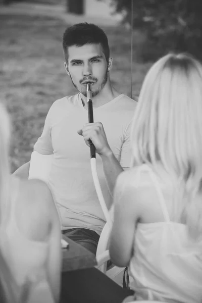 Homme vapeur narguilé pipe avec des filles dans shisha bar salon — Photo