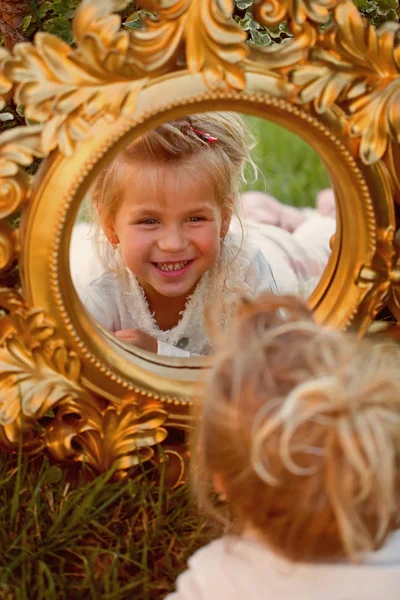 Sonrisa infantil en el espejo en el paisaje natural — Foto de Stock