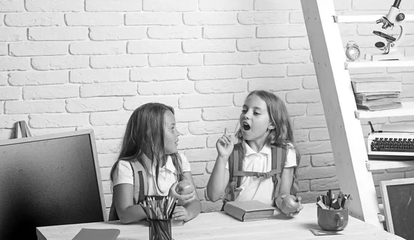 De schooltijd van meisjes. Kleine meisjes eet appel bij de lunchpauze. Gelukkig schoolkinderen op les in 1 september. Vriendschap van kleine zusters in de klas op de dag van de kennis. Terug naar school en huis het scholen — Stockfoto