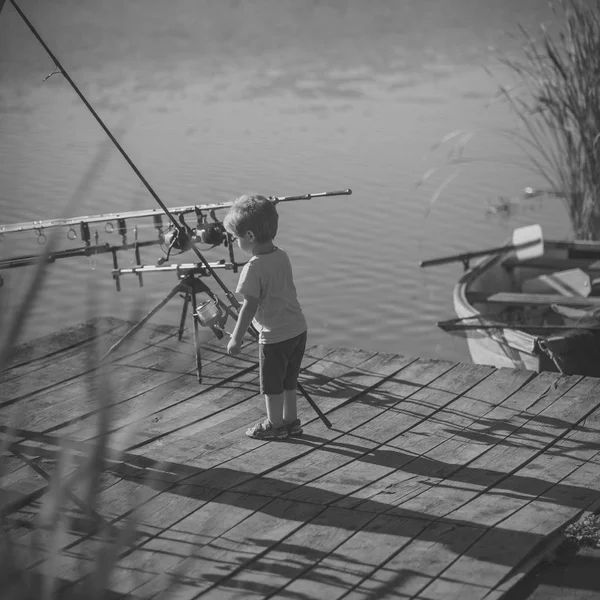 Petit garçon apprendre à attraper des poissons dans le lac ou la rivière — Photo