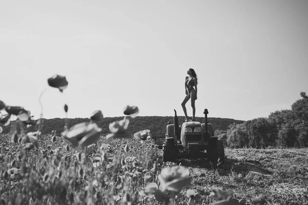 Agronómus nő a traktor, mák virág. — Stock Fotó