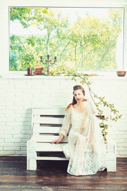 Güzel genç bir kadın bankta oturuyor..