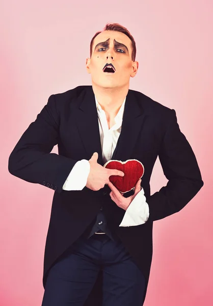 He is play acting he is in love. Comedian actor hold red heart. Mime actor has valentines celebration party. Mime man celebrate valentines day. Love confession. Happy valentines day