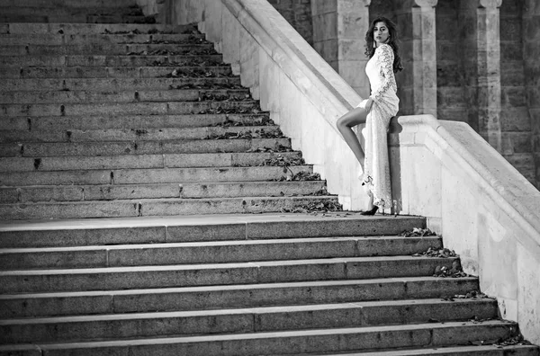 Linda noiva em vestido longo branco posando em escadas de mármore antes da cerimônia de casamento, noiva sexy em pé no vestido de escada — Fotografia de Stock