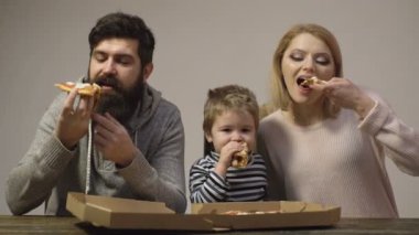 Mutlu bir aile pizza yemek. Anne, baba ve oğul birlikte pizza yiyorlar. Mutlu aile kavramı.