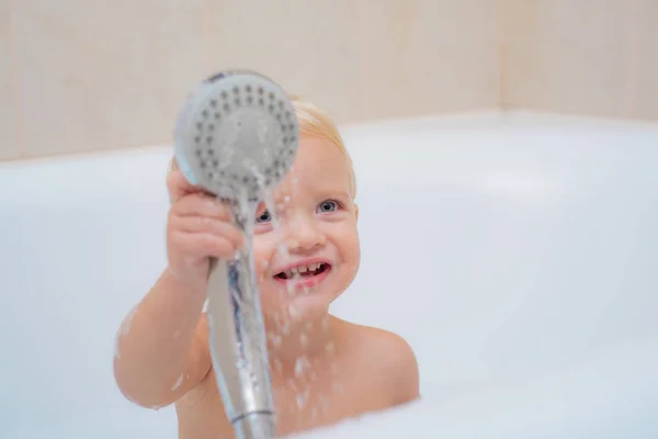 Salle de bains. Petit lavage de bébé avec une bulle dans le bain dans un chapeau. Joli petit garçon qui lave. Enfant en serviette propre et sèche. — Photo