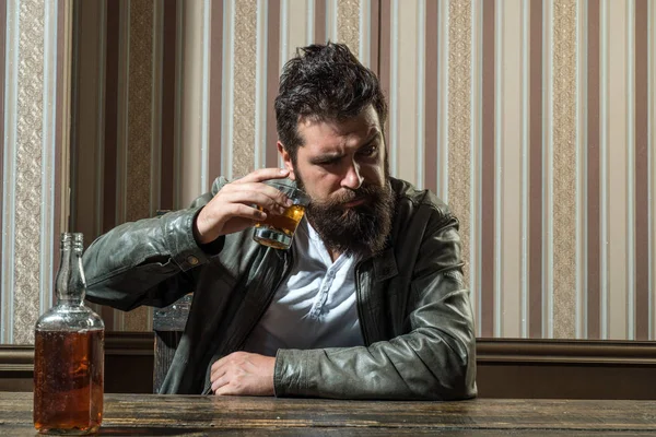 Man with beard holds glass brandy. Man holding a glass of whisky. Handsome stylish bearded man is drinking at home after work. Macho drinking. Degustation, tasting. — Stock Photo, Image