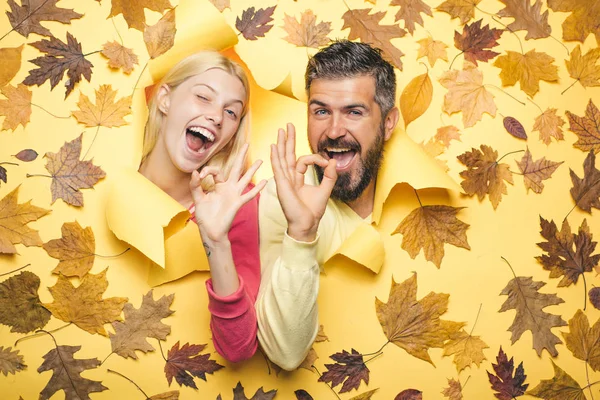 Happy couple in love wearing in autumn clothes on sunny day. Autumn couple wearing in autumn clothes and looks very sensually. Autumn mood and weather are warm and sunny and rain is possible.