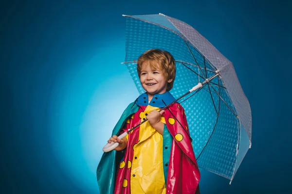 Hezký malý chlapík v přípravě na podzim. Veselý kluk v pláštěnce s Barevný deštník. Usměvavý chlapeček v módní sezónní oblečení s podzimní náladu. Veselý obličej. — Stock fotografie