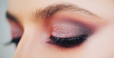 Güzel kadın yüzü. Makyaj modeli. Stüdyoda gri arka planda güzel bir genç kız.