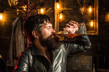 Viski yudumlarken. , Tatma degustation. Sakallı yakışıklı bir adam portresi. Vahşet ve eril kavramı. Sakallı, motorcu deri ceketli adam. Şık adam sakal portresi. Vintage
