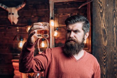Yakışıklı dalgın adam bir bardak viski tutuyor. Retro bar. Gece kulübü adam. Adam bir kokteyl içer. Sakallı adam oturuyor, bar.