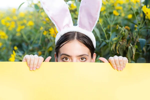 Mulher bonita com orelhas de coelho e cartaz em branco no espaço ao ar livre background.Copy. Páscoa . — Fotografia de Stock