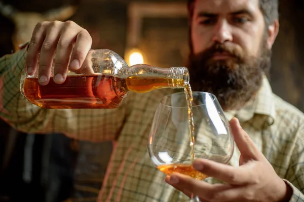 Degustační ochutnávka. Muž s plnovousem drží Sklenka brandy. — Stock fotografie