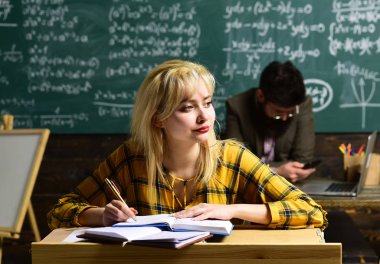 Öğretmen öğrencilerin hedefleri yeniden değerlendirmek zorunda kalacak. Grup öğrenci dersi veren eğitimli profesyonel. Birlikte masada oturan öğrenciler.