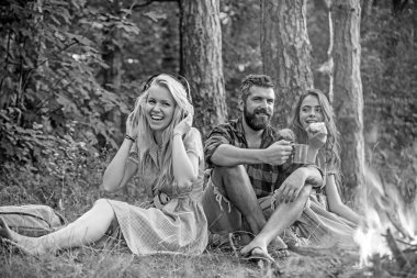 İnsanlar, vintage tarzı ormanda yangın kamp. Arkadaşlar şenlik ateşi ateşe sparks ile rahatlayın. Kadın ve kamp ateşi, sakallı adam. Yemek, eğlence ve kitap okuma. Yaz tatil kavramı