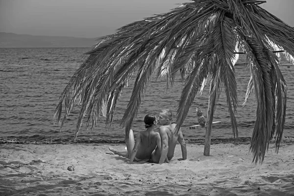 Famille et Saint Valentin. Vacances d'été et vacances de voyage au paradis. Relations amoureuses de couple nu sur le sable. Femme sexy et homme à l'ananas. Couple amoureux du corps sexy se détendre sur la plage . — Photo