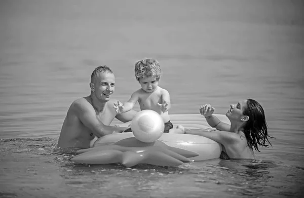 Nyaralás és utazás óceán. Apa és anya fiával, labdázni, vízben. Vagy ananász felfújható gumimatrac. Maldív-szigetek vagy Miami beach tevékenység öröm. Boldog családi pár, a Karib-tenger — Stock Fotó