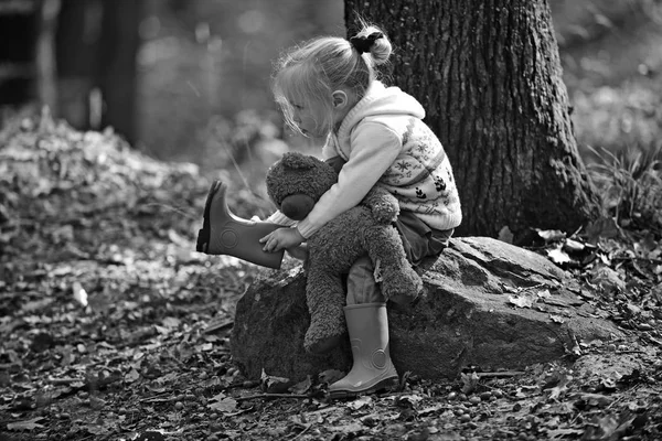 Kleines Mädchen im Herbstwald mit Teddybär. Kleines Mädchen erkundet die Natur an einem Herbsttag. — Stockfoto