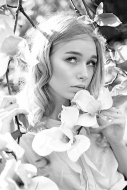 Rüya gibi yüz, Manolya çiçek, Doğa arka plan yakınındaki ihale sarışın kız. Genç kadın çiçek Bahçe keyfini çıkarın. Bayan park güneşli bahar gününde yürür. Bahar bloom kavramı.