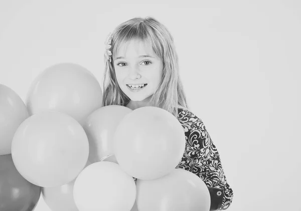 Liten flicka barn med party ballonger, firande. Liten flicka med frisyr håller ballonger. Snålt med ballonger på födelsedag. Skönhet och mode, slagkraftig pasteller. Födelsedag, lycka, barndom, titt. — Stockfoto