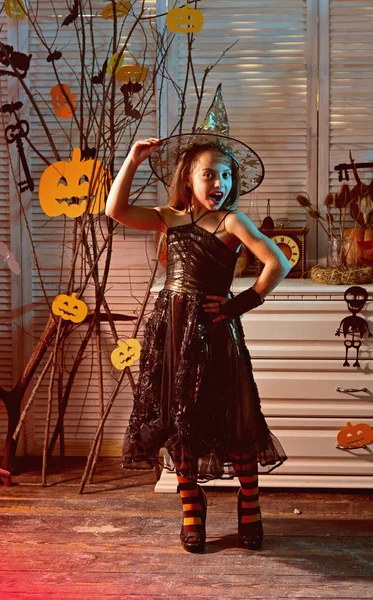 Little girl do magic trick on halloween. Little girl in magic hat have fun on halloween night. She has powerful magic. Spell require too much magic