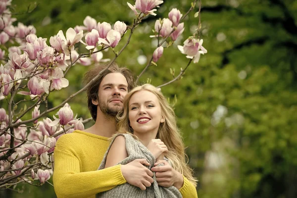 Την άνοιξη. ευτυχισμένο ζευγάρι στην αγάπη στην άνοιξη του magnolia λουλούδια — Φωτογραφία Αρχείου