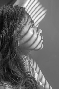 Uzun esmer saçlı güzel kız. Işık ve gölge panjurlar genç sağlıklı cilt üzerinde gelen kadınla. Doğal makyaj kadınla banyoda sakin ol. Güzellik moda bakmak modeliyle. Spa wellness ve sağlık