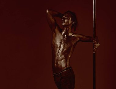 Pilon üzerinde dans gümüş gövde sanat kaslı adam. Atletik erkekleri pilon üzerinde akrobatik öğeleri gösteriyor. Pole dans spor. Metal yüzey ile seksi maço. Güçlü dansçı egzersiz kutup. Özgürlük.