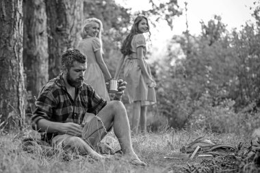 Arkadaşlar ormanda kamp keyfini çıkarın. Arka plan bulanık kadın ile adam içki çay şenlik ateşi, sakallı. Hippi sakal oturup kamp ateşi ile. Yaz tatil kavramı. Kamp ve yürüyüş ve turistik