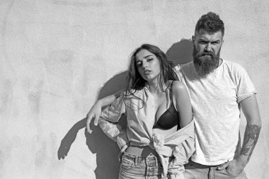 Sakal ve Bayan sıcak güneşli günde kibirli yüzünde olan adam. Çift ısı yaz gününde, arka plan, kopya alanı duvarda uğrar. Kız açılarak forması altında siyah sutyen takıyor. Sıcak ve seksi kavramı.