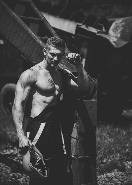 Sexy handyman concept. Muscular builder holds hard hat — Stock Photo, Image