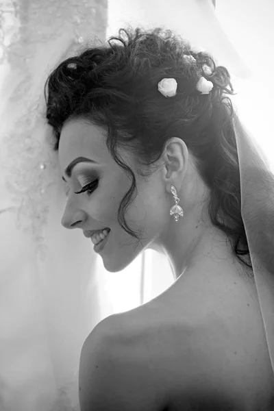 Woman with bridal veil on brunette hair. Happy bride smile on wedding day. Sensual woman with professional makeup. Fashion girl with glamour look and beauty. Wedding morning preparation