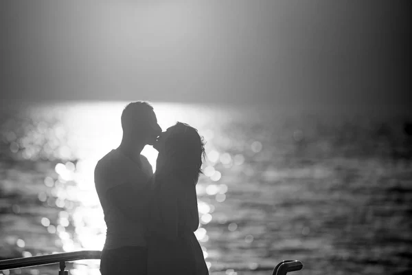 Pareja besándose en la playa con una hermosa puesta de sol en el fondo . —  Fotos de Stock