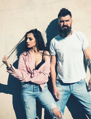 Sakal ve Bayan sıcak güneşli günde kayıtsız yüzünde olan adam. Sıcak ve seksi kavramı. Çift ısı yaz gününde, arka plan, kopya alanı duvarda uğrar. Kız açılarak forması altında siyah sutyen takıyor.