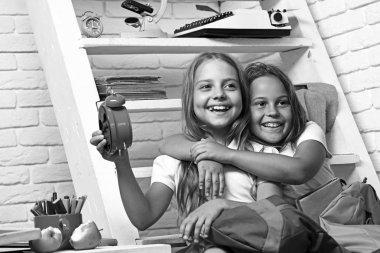 Okulda kamera bakıyor ve çalar saat tutan mutlu okul.