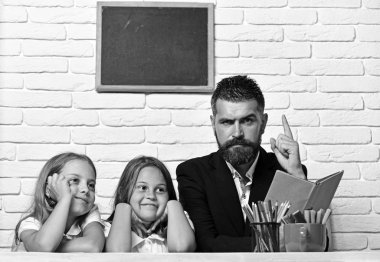 Baba ve kızı gönüllülük a kitap birlikte masada.