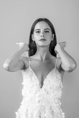 Moda model veya balosunda prenses. Kadın pembe arka planda yazlık elbise üzerinde. Düğün töreninde gelin kız. Düğün moda ve güzellik salonu. Şık saç ile beyaz elbiseli seksi kız