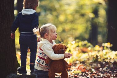 Kız ve erkek kardeş temiz hava iyi eğlenceler. Küçük oğlan ve kız ormanda kamp arkadaşlar. Çocukluk ve çocuk dostluk, sevgi ve güven. Kids hareket ve aktif dinlenme. Çocuk sonbahar ormanda oyun