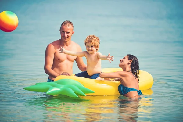 パイナップル インフレータブルまたはエアコンのマットレス。父と息子と母は、水でボールをプレーします。モルディブまたはマイアミ ビーチ活動の喜び。カリブの海に幸せな家族カップル。夏休み、海への旅行 — ストック写真