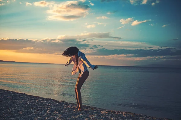 Sexy Frau tanzen auf karibischem Meer in Bahamas bei Sonnenuntergang. Mädchen entspannen auf Kieselstrand Mode Badeanzug. Sommerurlaub und Reise ans Meer. Mode und Beauty-Look. Malediven oder miami beach water — Stockfoto