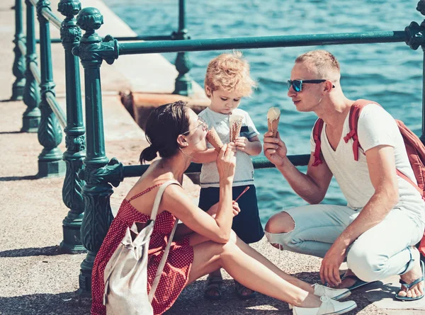 母亲和父亲与儿子在海上吃冰淇淋。快乐家庭的暑假。孩子与父亲和母亲。家庭旅行与孩子在母亲或父亲天。爱和信任作为家庭价值. — 图库照片
