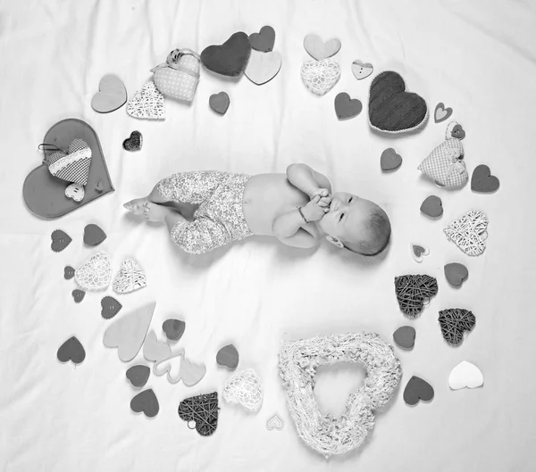 Cute baby girl. Childhood happiness.Valentines day. Love. Portrait of happy little child. Small girl among red hearts. Sweet little baby. New life and birth. Family. Child care — Stock Photo, Image