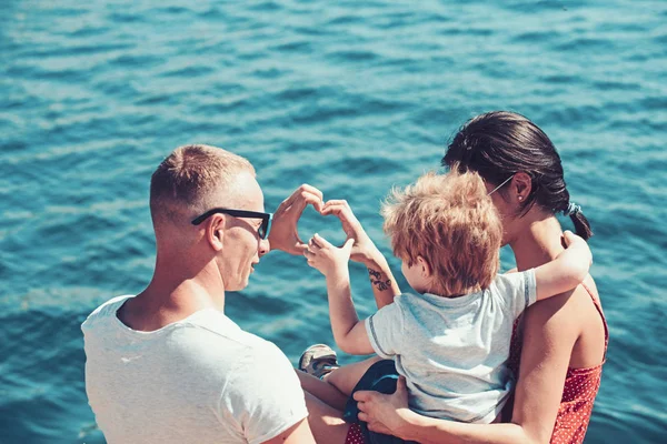 息子父と母は、海のビーチで泳ぐ。父と母と子。家族は、母親や父親の日に子供と一緒に旅行します。愛と家族の価値観と信頼。幸せな家族の夏休み. — ストック写真