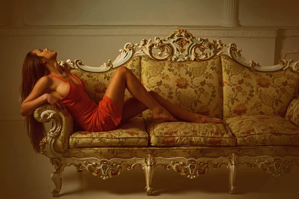 Модна жінка з модним виглядом розслабляється на дивані. Мода ніколи не спить — стокове фото