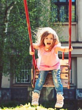 Oyun park alanında. Yaz aylarında oynayan küçük çocuk. Mutlu gülen kız çocuk salıncak üzerinde. swing, tatlı rüyalar romantik küçük kız. çocukluk hayal .teen özgürlük. Etkin gün
