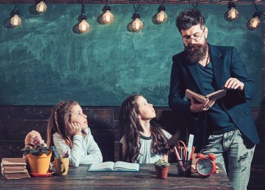 Adam öğretmen öğrencilere ders kitabını okudum. Adam öğretmen kız öğrenciler sınıfta öğretmek