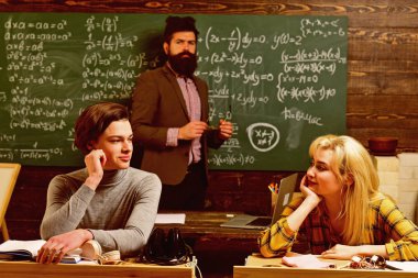 Modern öğretmen hippi matematik formülü ile büyük yazı tahtası üzerinde yazılı. Eğitim ve okuma birlikte lise üniversite öğrencileri Eğitim kavramları sınıf. Öğretmenler itibar altındır.